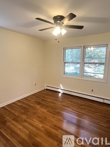 A room with a ceiling fan and a window.