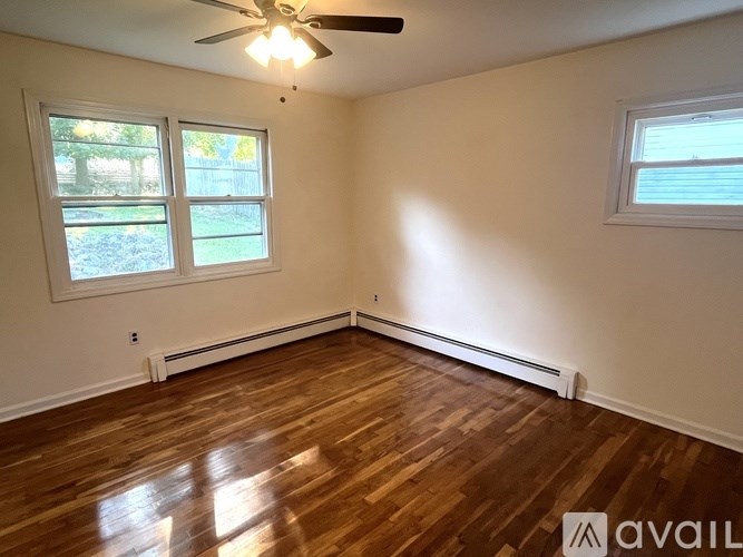 A room with wooden floors and a ceiling fan.
