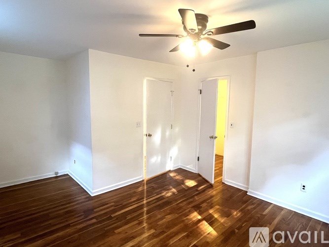 A room with a ceiling fan and wooden floors.