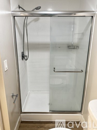 A shower stall with a glass door and a silver frame.