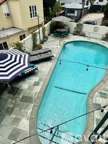 A small pool with a table and chairs around it.