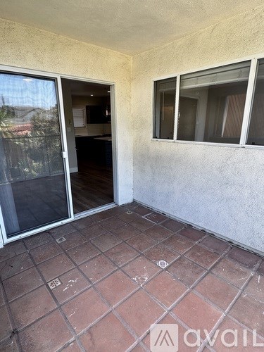 A patio with a tiled floor and a sliding glass door.