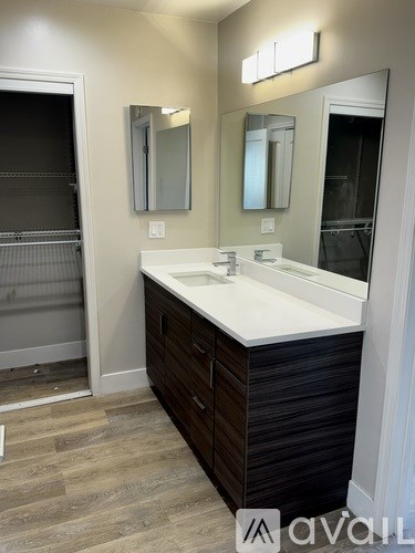 A bathroom with a white sink and a mirror above it.