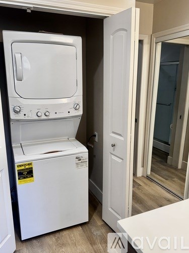 A white dishwasher with a sticker on it is in a room.