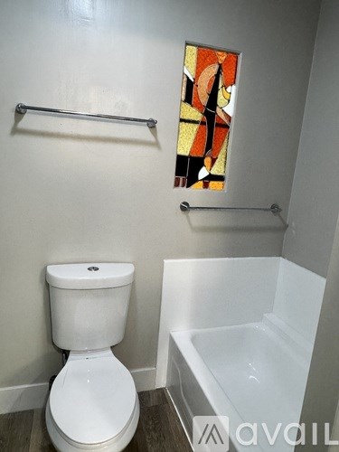 A white toilet sits next to a bathtub in a bathroom.
