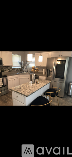 A kitchen with a granite countertop and a black stool.