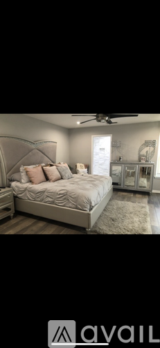 A bedroom with a large bed and a ceiling fan.