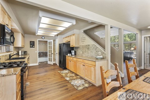 A kitchen with wooden cabinets and a black refrigerator.