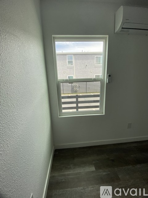 A room with a window and a white wall.