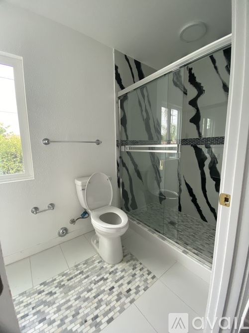 A white toilet in a bathroom with a glass shower door.