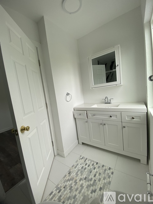 A bathroom with a white sink and a mirror above it.