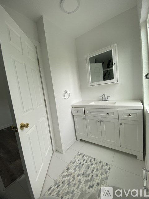 A bathroom with a white sink and a mirror above it.