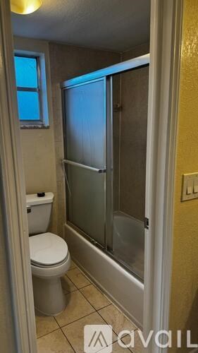 A park with a pond, people, and trees.