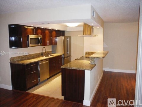 A kitchen with dark wood cabinets and granite countertops.