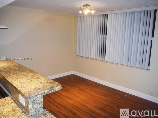 A room with a marble bench and wooden flooring.