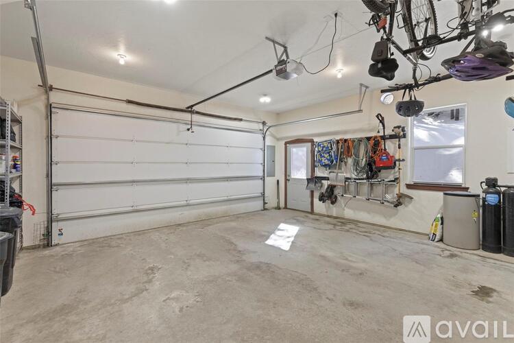 A spacious garage with a white ceiling and a large white door.