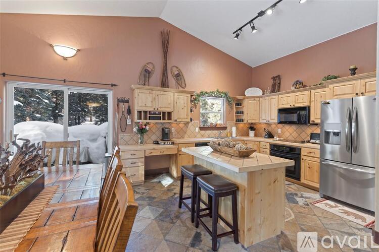 A kitchen with wooden cabinets and a large island in the middle.