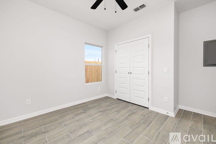 A room with a ceiling fan and a door leading to a balcony.