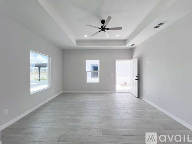 A spacious room with a ceiling fan and tiled flooring.