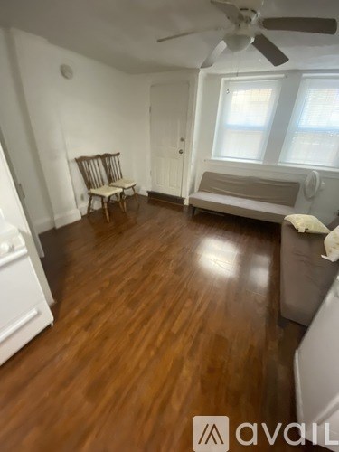 A room with wooden floors and a ceiling fan.