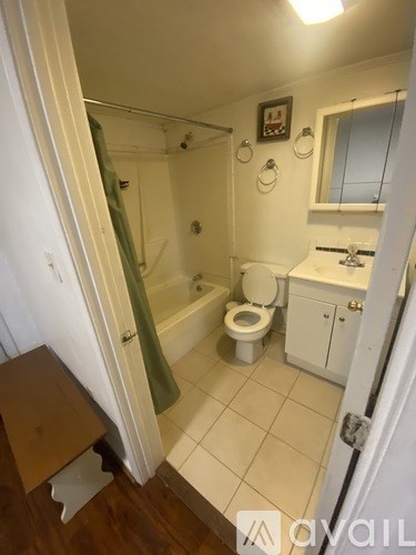 A small bathroom with a toilet, sink, and shower.