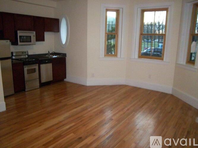 A kitchen with wooden floors and white walls.