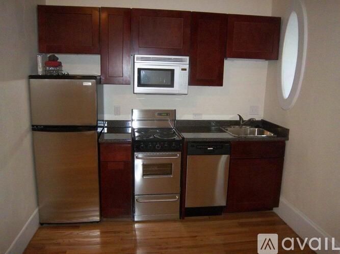 A kitchen with brown cabinets and stainless steel appliances.