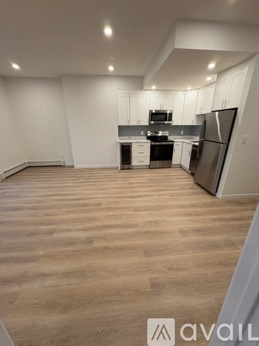A kitchen with wooden floors and white walls.