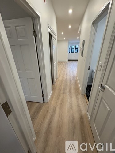 A hallway with wooden floors and white doors.