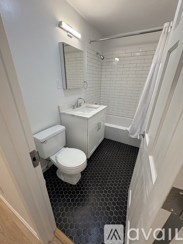 A bathroom with a toilet, sink, and shower.