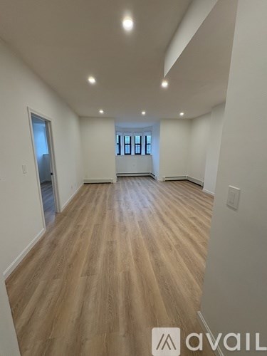 A room with wooden flooring and a window.