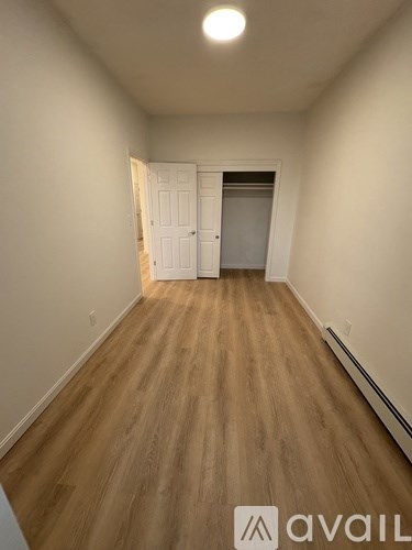 A room with wooden flooring and a white door.