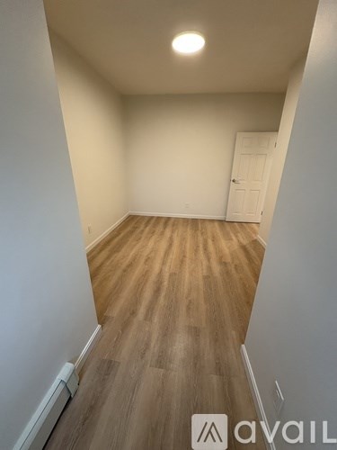 A room with wooden flooring and a white door.