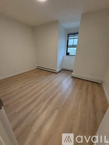 A room with wooden flooring and a window.