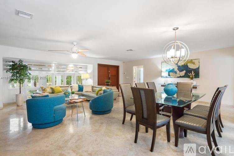 A modern dining room with a glass table and chairs.