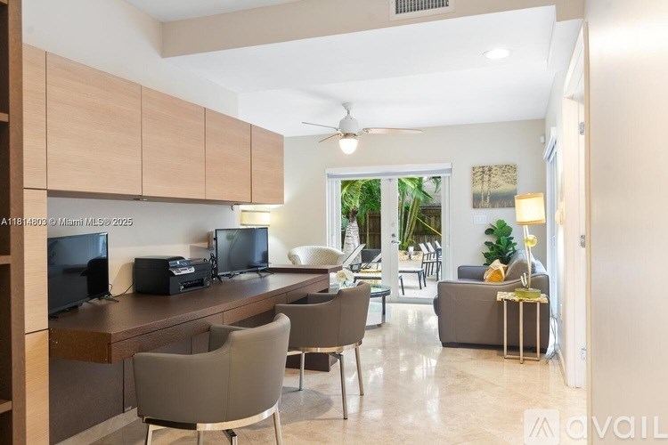 A living room with a brown sofa, a wooden table, and a television.