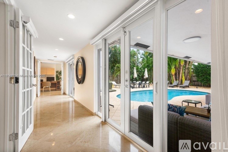 A long hallway with a pool outside.