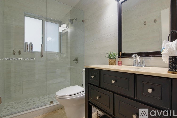 A bathroom with a toilet, sink, and mirror.