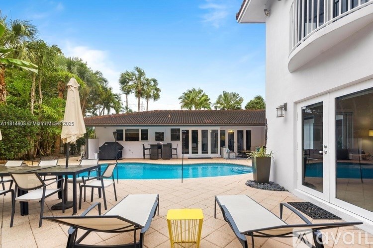 A poolside area with a white building in the background.