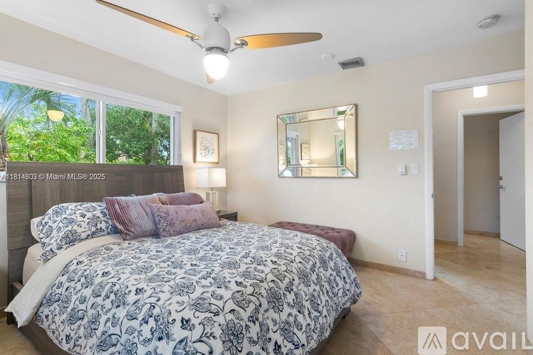 A bedroom with a large bed and a ceiling fan.