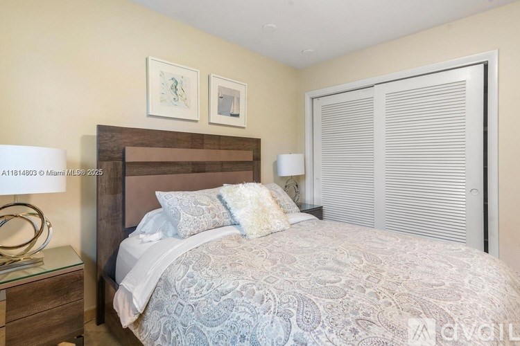 A bedroom with a bed, nightstand, and two pictures on the wall.