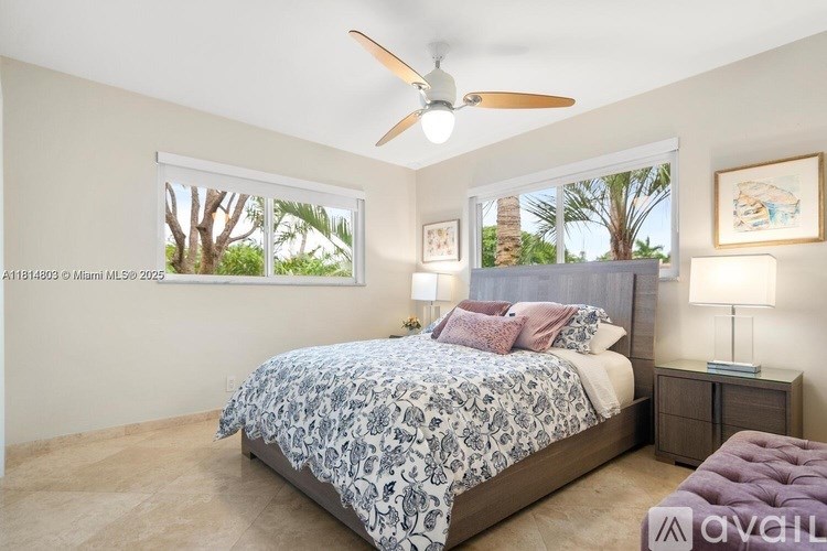 A bedroom with a bed, nightstands, and a ceiling fan.