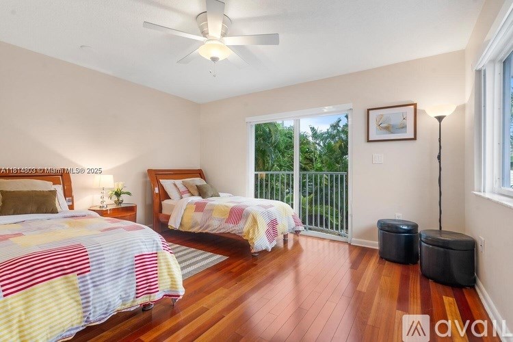 A bedroom with two beds and a balcony.