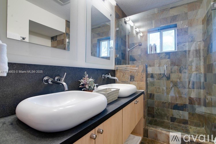 A bathroom with a white sink and a mirror above it.