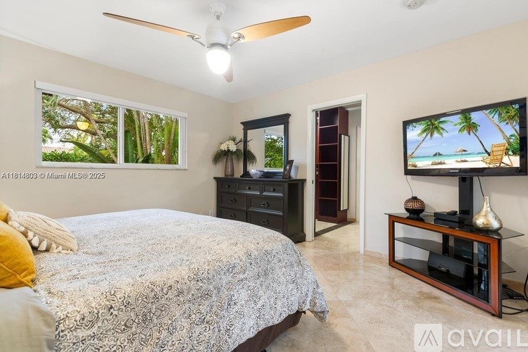 A bedroom with a bed, dresser, and television.