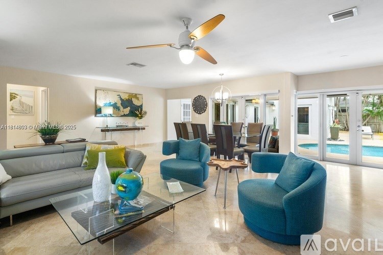 A living room with a grey sofa, a blue armchair, and a glass coffee table.