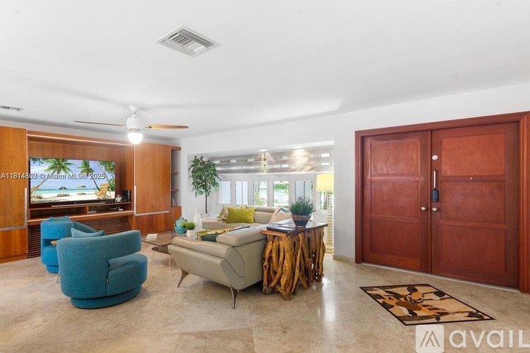 A living room with a blue armchair, a wooden entertainment center, and a rug.