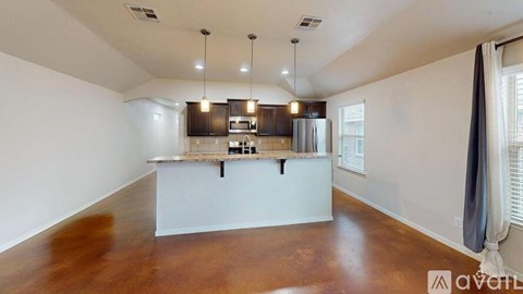 A kitchen with a refrigerator, microwave, and oven is shown in the image.