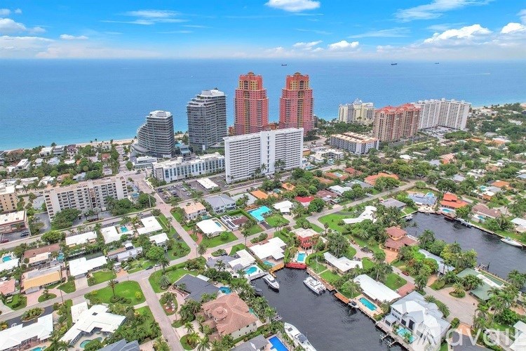 A cityscape with a large body of water in the foreground and a clear blue sky above.
