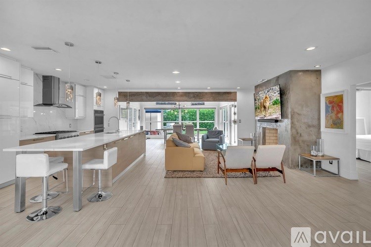 A modern kitchen with white cabinets and a dining area with a white table and chairs.